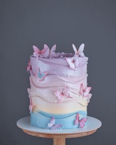 a multi layer cake with butterflies on it