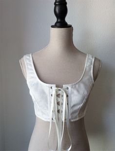 Regency short stays from Haizea Couture Front lacing bustier empire stay great for renfaire costume! This amazing rennaisance bustier is made of white cotton brocade fabric. It has 4 sprung steel bones and satin lacing at front. SIZE CHART Ideally suited for someone with the following measurements: Size XS Bust: 79cm-85cm / 31''-33'' Size S Bust: 84cm-90cm / 33''-35'' Size M Bust: 89cm-95cm / 35''-37'' Size L Bust: 94cm-100cm / 37''-39'' SHORT STAYS DETAILS ⚬ Handmade to order, we need 4 to 8 we Regency Short Stays, Regency Stays, Stays Pattern, Elven Wedding Dress, Short Stays, Wedding Cloak, Ren Faire Costume, Wedding Corset, Lace Bustier