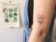 a woman's arm with a tattoo on it that says mom in a heart