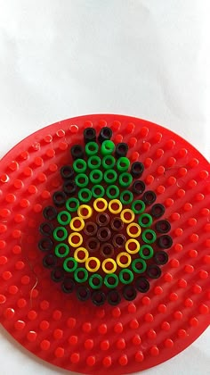 a red plate with black, yellow and green circles on it