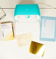 some items are laying out on a white table with a blue case and gold foil