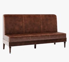 a brown leather couch sitting on top of a wooden frame