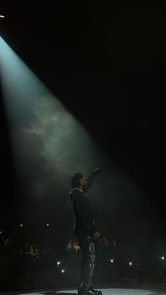 a man standing on top of a stage holding a microphone in front of a crowd