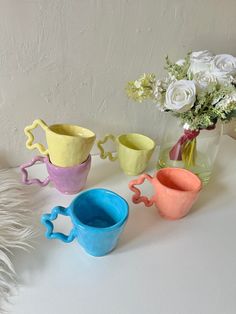 three vases with flowers in them sitting on a white counter top next to each other