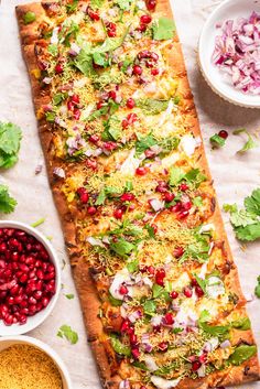 a flatbread topped with vegetables and other toppings next to bowls of seasoning