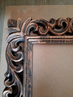 an ornate wooden frame on the wall with a mirror in it's center and bottom corner