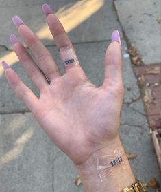 a person's hand with two small tattoos on it