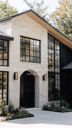 a white brick house with black doors and windows