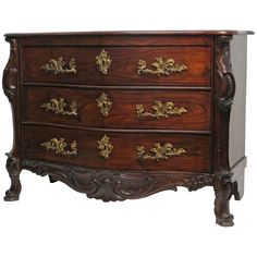 an antique chest of drawers with gold decorations