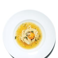 a white plate topped with pasta and an egg