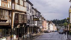 an old european town street with cars parked on the side