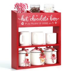 a red shelf with white mugs and candy canes on the top, next to two jars filled with hot chocolate