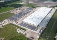 an aerial view of a large building under construction in the middle of a rural area