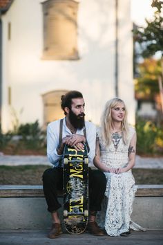 a man sitting next to a woman holding a skateboard