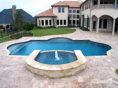 a large swimming pool in the middle of a yard with a fountain on one side