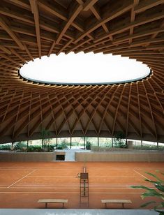 a tennis court with benches and a skylight in the center is made out of wood