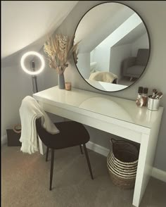 a white desk with a round mirror above it and a black chair next to it