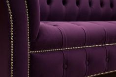 an upholstered purple couch with gold studding