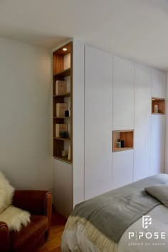 a bedroom with a bed, chair and bookshelf next to a window on the wall