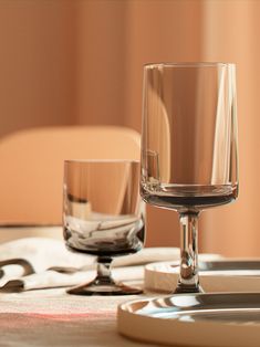 an empty wine glass sitting on top of a table next to a fork and knife