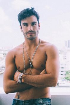 a shirtless man standing with his arms crossed