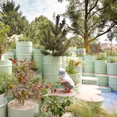 a small child is playing with some plants in the middle of an outdoor garden area