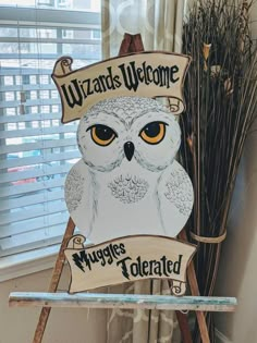 an owl is sitting on top of a sign that reads wizard's welcome wyggies related