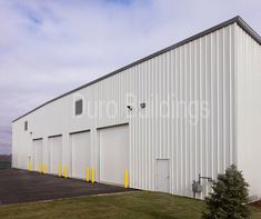 a large white building with yellow trim on the front and side doors that are closed