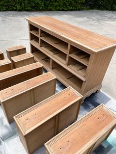 a bunch of wooden furniture sitting on top of a cement floor next to each other