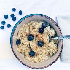 a bowl filled with oatmeal and blueberries on top of a table