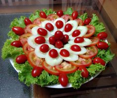 a salad with tomatoes, lettuce and cheese on it sitting on a table