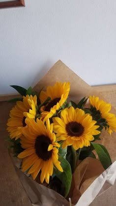 a bouquet of sunflowers in a brown paper bag