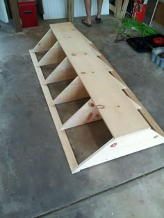 a person standing next to a shelf made out of plywood and some wood planks