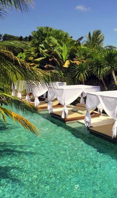 an outdoor swimming pool with white drapes over it