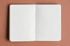 an open notebook on a brown surface