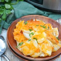 a wooden bowl filled with potatoes and cheese