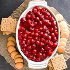 a white bowl filled with cranberry sauce surrounded by crackers