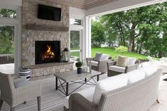 a living room filled with furniture and a fire place in front of a large window