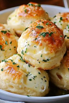 a white bowl filled with biscuits covered in cheese