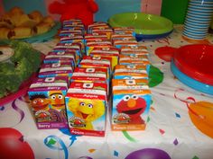 the table is set up with many boxes of yogurt and other snacks on it