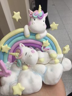 there is a small toy unicorn laying on top of a rainbow