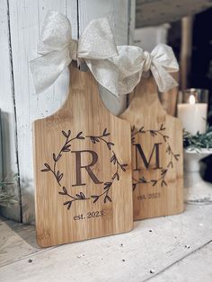 two wooden cutting boards with the initials r and m on them, sitting next to each other