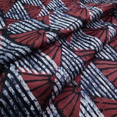 a red and black abstract print fabric with white lines on the bottom half of it