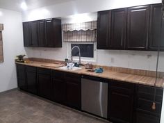 a kitchen with black cabinets and stainless steel dishwasher