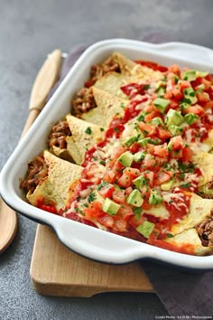 a white casserole dish filled with meat and veggies