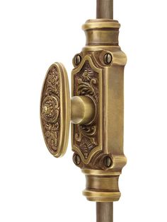 an antique brass door handle with ornate designs on the front and back of it, against a white background