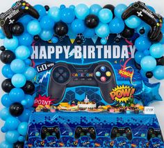 an image of a birthday party decoration with video game controller balloons and streamers on the table