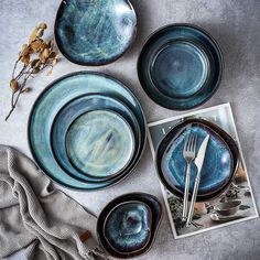 blue plates and silverware are laid out on a table