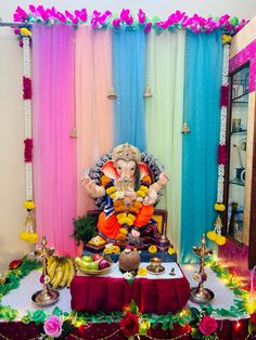 there is a statue of lord ganesh in front of the colorful curtained room