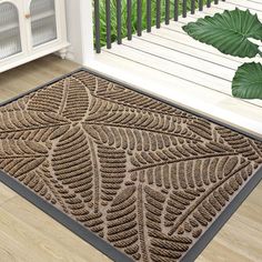 a door mat with an intricate design on the outside and inside, in front of a porch